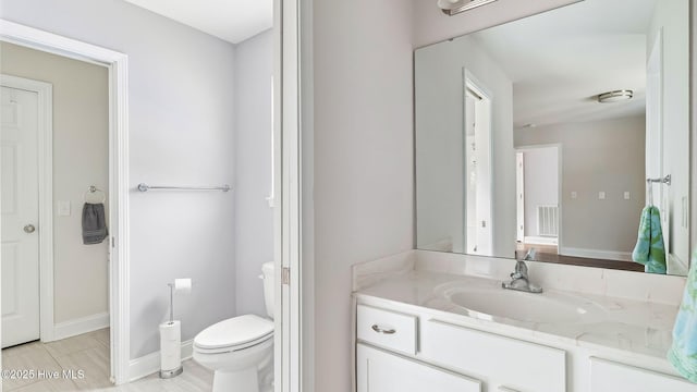 bathroom featuring visible vents, toilet, vanity, and baseboards