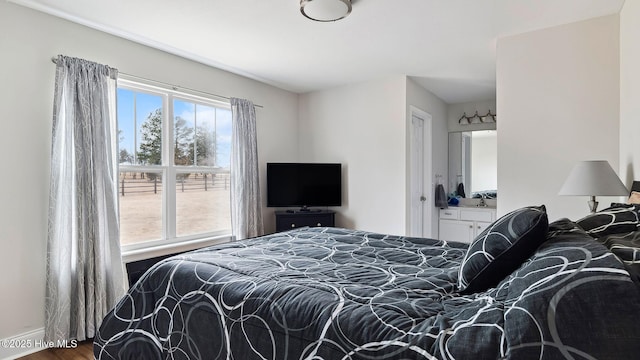 bedroom with multiple windows and wood finished floors