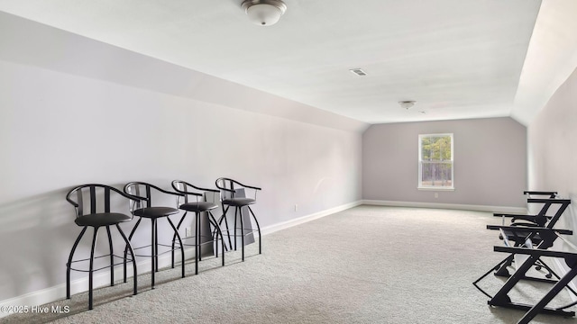 sitting room with lofted ceiling, baseboards, visible vents, and carpet floors