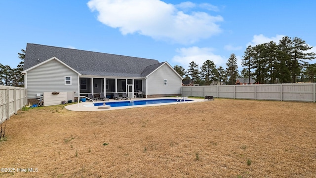 rear view of house with a fenced in pool, roof with shingles, a yard, a fenced backyard, and a sunroom