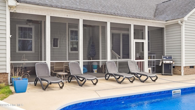 outdoor pool featuring grilling area, a patio area, and a sunroom