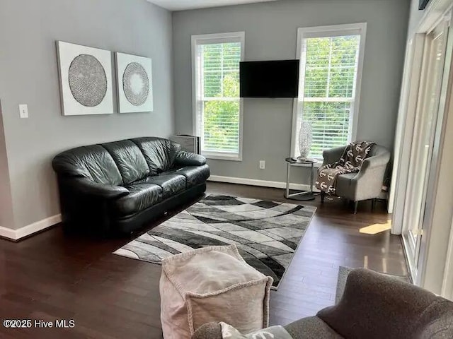 living room with baseboards and dark wood-style flooring