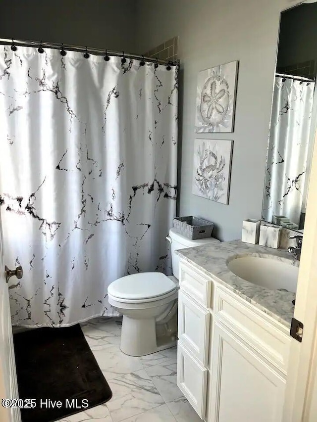 bathroom with curtained shower, toilet, marble finish floor, and vanity