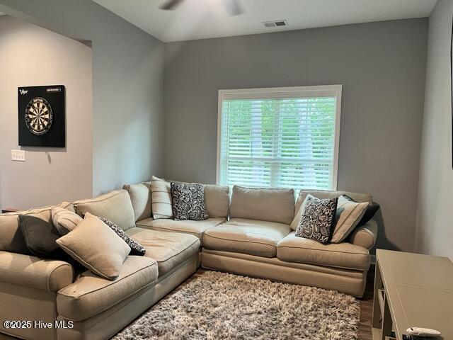 living area featuring visible vents and a ceiling fan