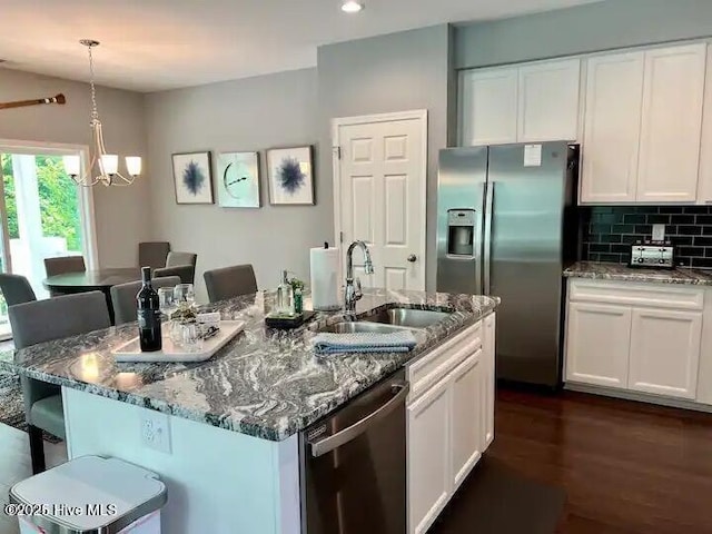 kitchen featuring white cabinetry, stone countertops, appliances with stainless steel finishes, and a sink