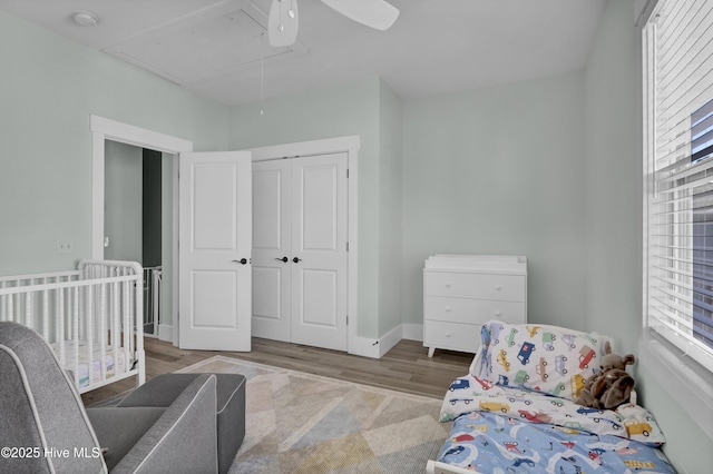 bedroom featuring a closet, multiple windows, attic access, and a ceiling fan