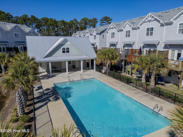 community pool with a patio area, a residential view, and fence