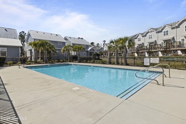 community pool with a patio area, a residential view, and fence