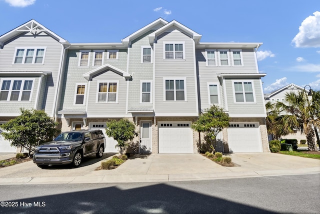 multi unit property featuring driveway and a garage