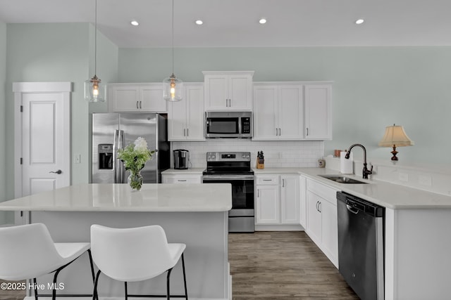 kitchen featuring a sink, stainless steel appliances, a kitchen bar, and tasteful backsplash