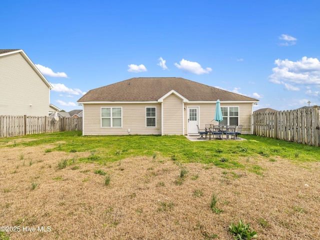 rear view of house featuring a lawn, a fenced backyard, and a patio area