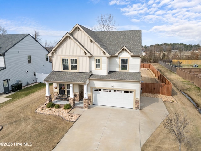 view of front of home featuring fence, an attached garage, covered porch, a shingled roof, and board and batten siding