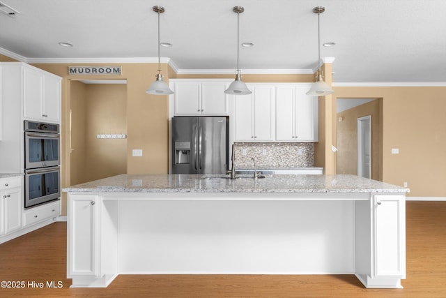 kitchen with a sink, stainless steel appliances, white cabinetry, and light wood finished floors