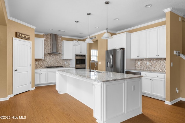 kitchen featuring light wood-type flooring, a sink, white cabinetry, appliances with stainless steel finishes, and wall chimney range hood