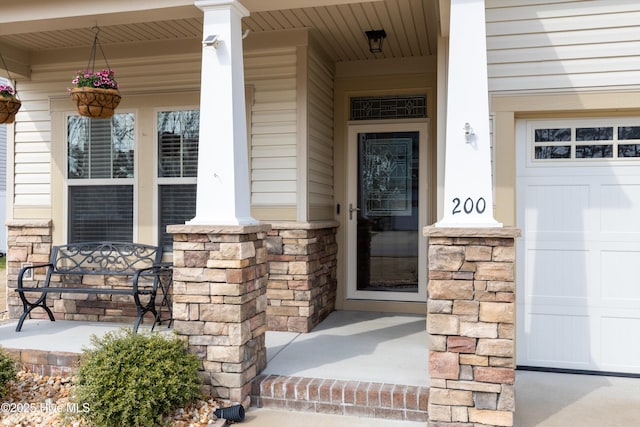 view of exterior entry featuring stone siding and a porch