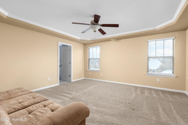 unfurnished room featuring a ceiling fan, a tray ceiling, carpet, and baseboards