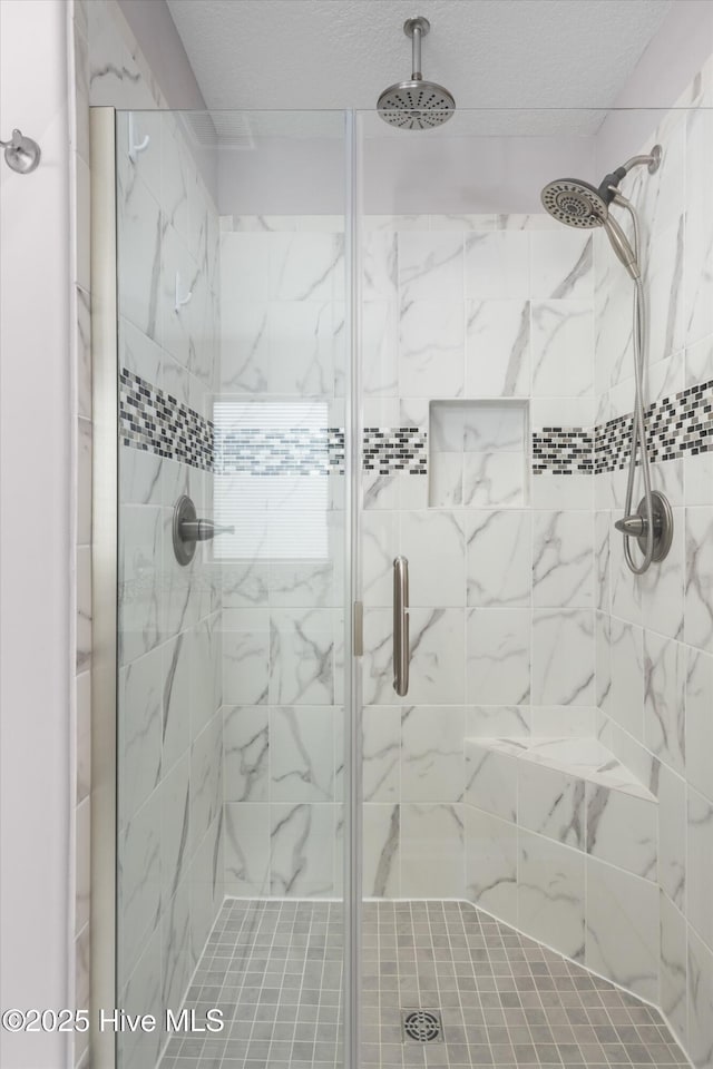 bathroom featuring a shower stall and a textured ceiling