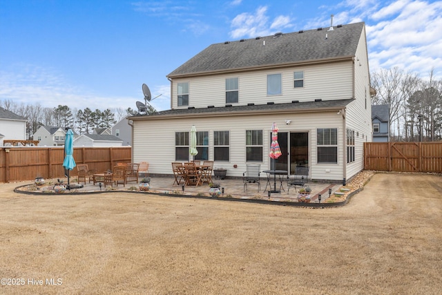 rear view of house featuring a patio and fence