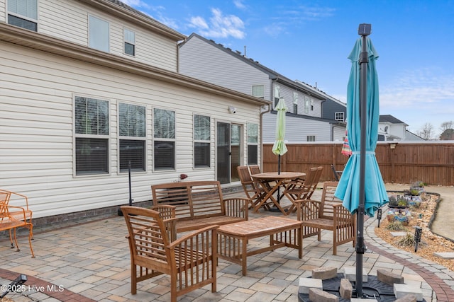 view of patio with outdoor dining space and fence