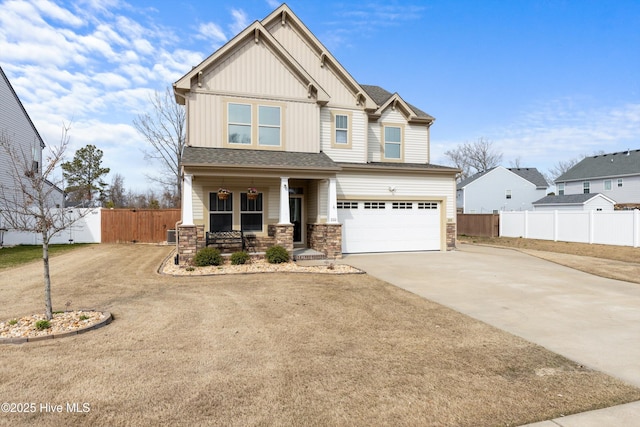 craftsman house featuring covered porch, board and batten siding, concrete driveway, and fence