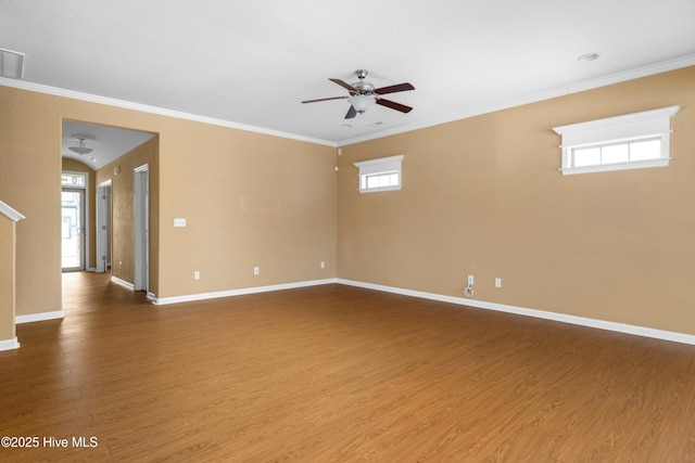 empty room with baseboards, wood finished floors, ceiling fan, and ornamental molding