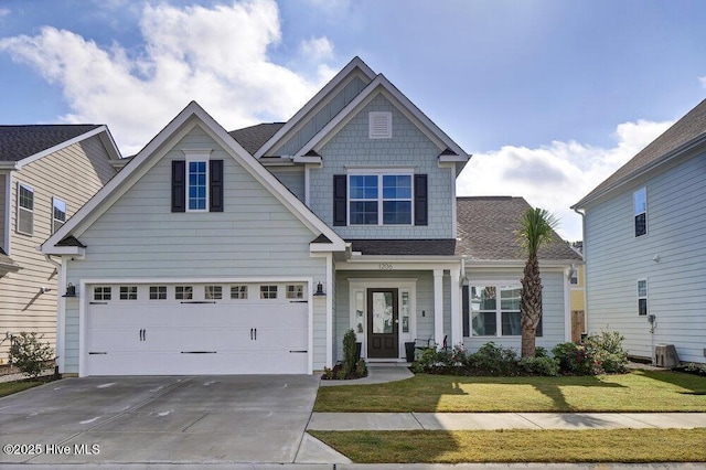 craftsman inspired home with driveway, a front yard, and roof with shingles