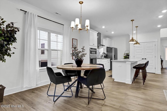 dining space featuring recessed lighting, light wood-style floors, visible vents, and a chandelier