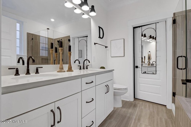 full bathroom with a sink, a stall shower, and double vanity