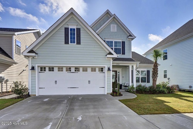 view of front of property featuring a front yard, a garage, and driveway