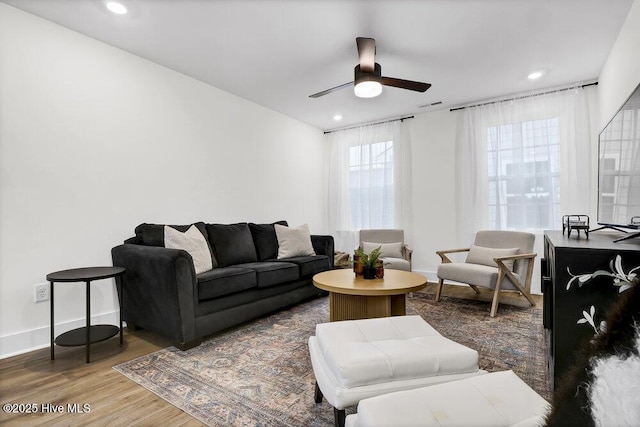 living room featuring a ceiling fan, wood finished floors, visible vents, baseboards, and recessed lighting