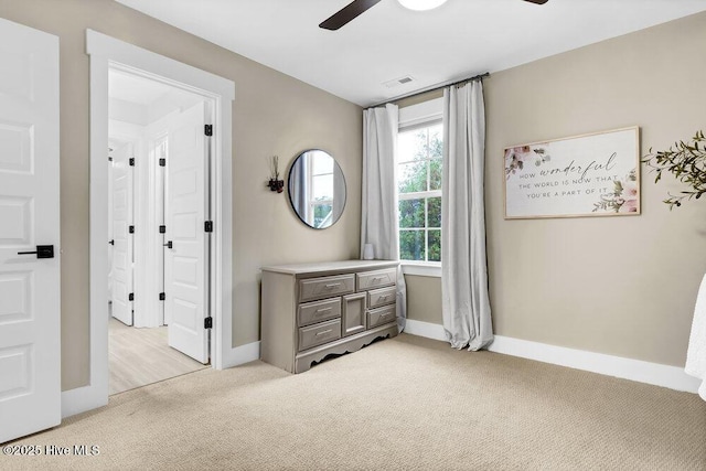 bedroom featuring a ceiling fan, light colored carpet, visible vents, and baseboards