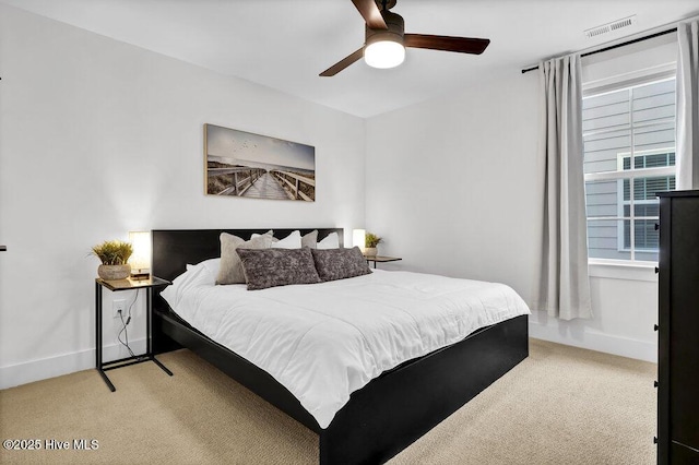 bedroom featuring ceiling fan, baseboards, visible vents, and light carpet