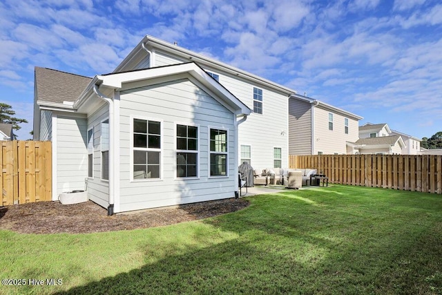 back of property with a patio area, a lawn, a fenced backyard, and an outdoor hangout area