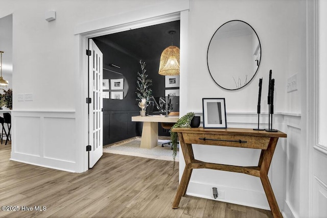 office with a wainscoted wall, wood finished floors, and a decorative wall