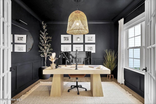 home office with a decorative wall, wood finished floors, a wainscoted wall, and ornamental molding