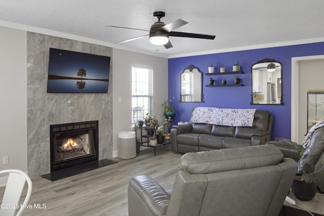 living room featuring a fireplace, crown molding, and wood finished floors