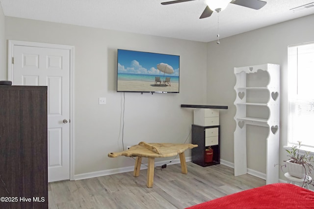 bedroom with multiple windows, wood finished floors, visible vents, and baseboards