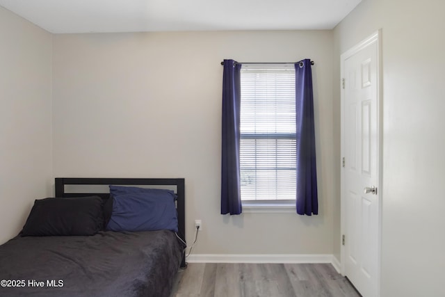 unfurnished bedroom featuring wood finished floors and baseboards