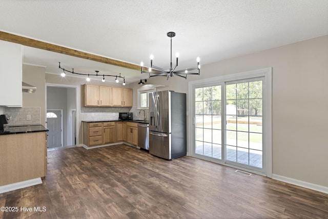 kitchen featuring light brown cabinetry, dark wood finished floors, stainless steel appliances, an inviting chandelier, and decorative backsplash