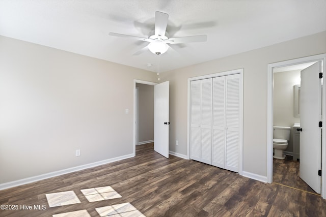 unfurnished bedroom with a ceiling fan, baseboards, ensuite bath, dark wood-type flooring, and a closet