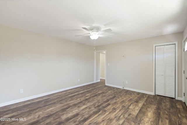 unfurnished bedroom with a ceiling fan, dark wood-style floors, baseboards, and a closet