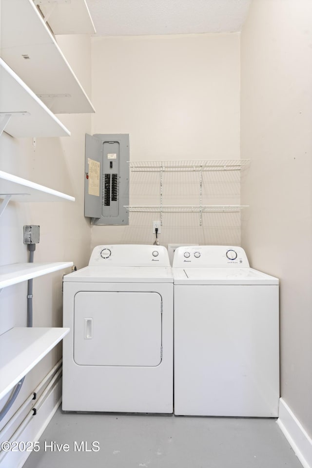 clothes washing area featuring electric panel, laundry area, and washing machine and clothes dryer