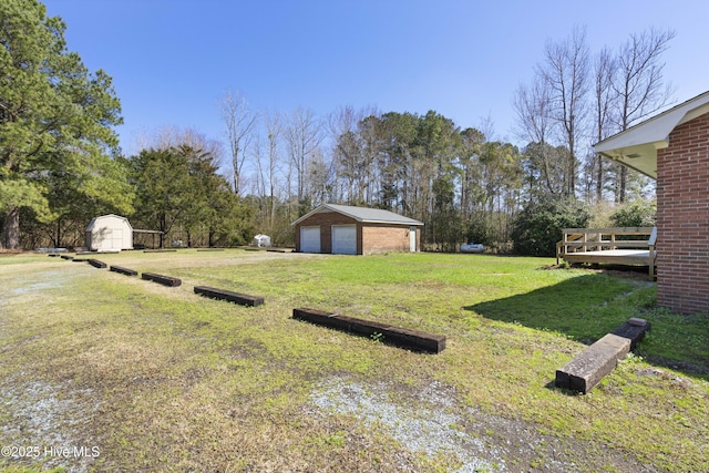 view of yard with a detached garage, a storage shed, and an outdoor structure