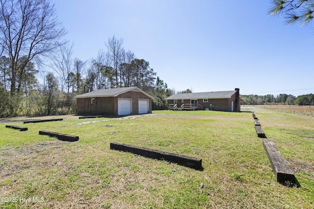 view of yard featuring an outdoor structure and a detached garage