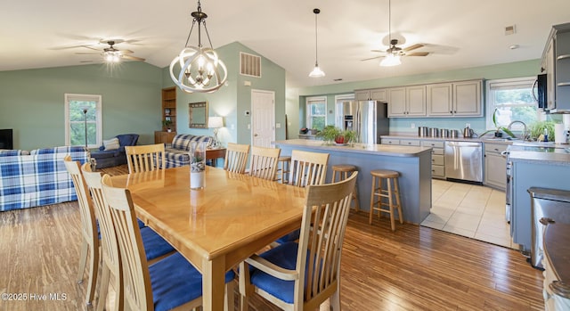 dining room featuring lofted ceiling, visible vents, and ceiling fan