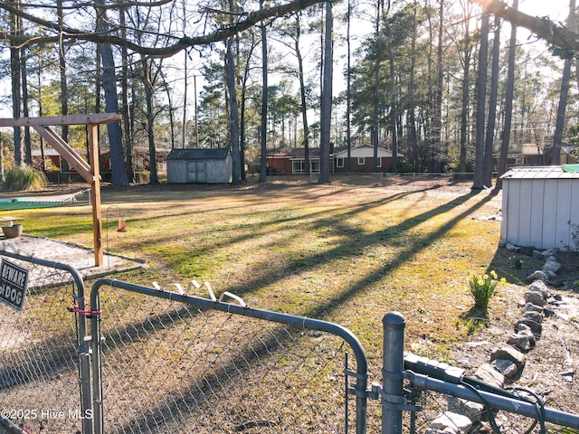 view of yard featuring an outbuilding, a storage shed, and fence