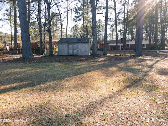 view of yard with a storage unit, an outdoor structure, and fence