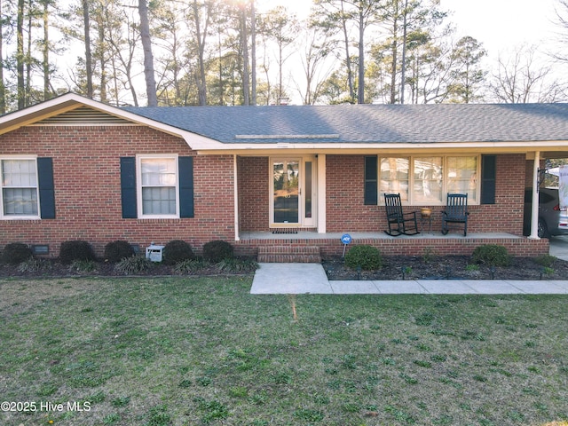 ranch-style house featuring brick siding, a porch, a front yard, and a shingled roof