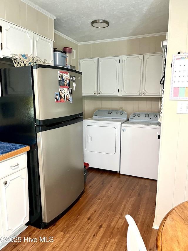 laundry area with washer and clothes dryer, a textured ceiling, wood finished floors, and ornamental molding