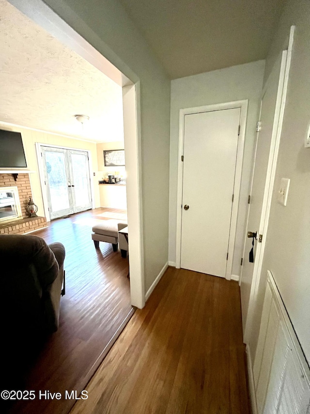 corridor with french doors, baseboards, and wood finished floors